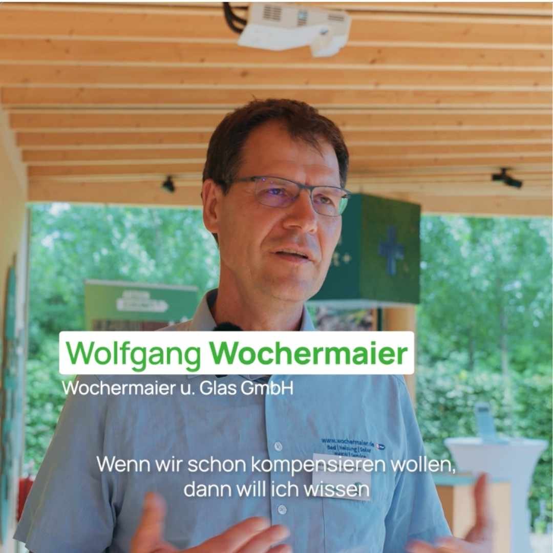 Auf dem Bild ist ein Mann zu sehen, der vor einer Kamera ein Interview hält.